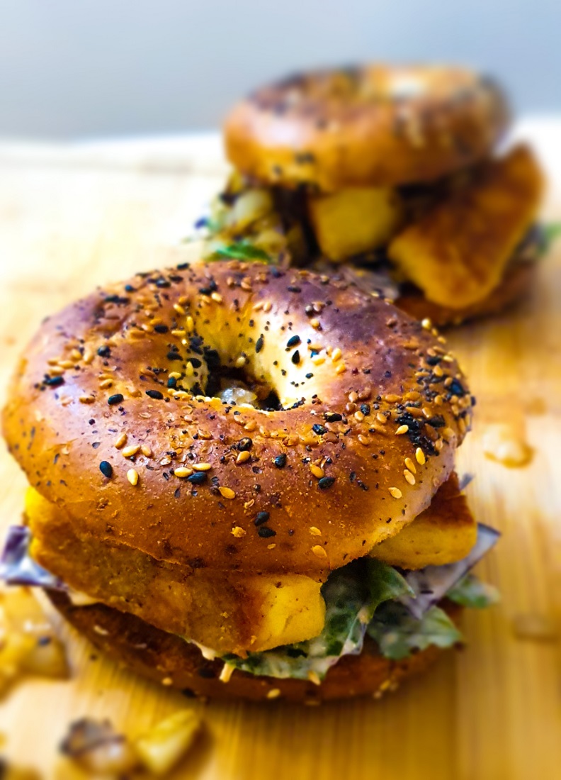 crispy halloumi and coleslaw in poppyseed bagels on a wooden board