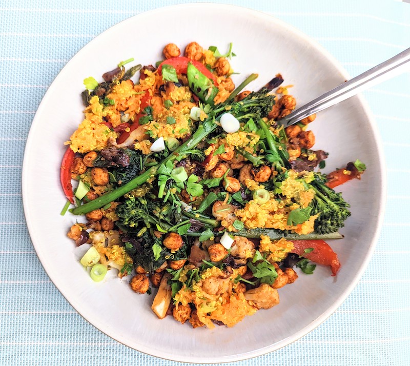 quinoa with crispy chickpeas and vegetables in a bowl with a blue background